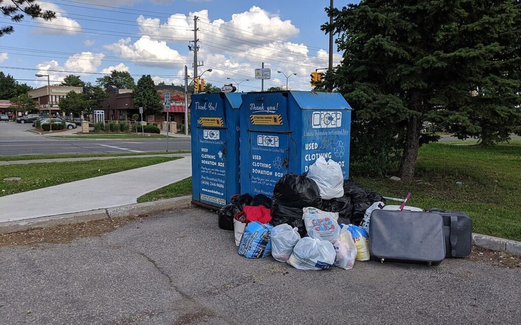 Conteneurs de collecte de vêtements à Toronto, sacs et valises déposés à leur pied