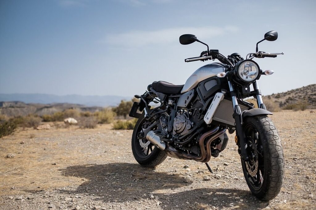 Moto roadster garée sur un terrain sec, collines en arrière-plan