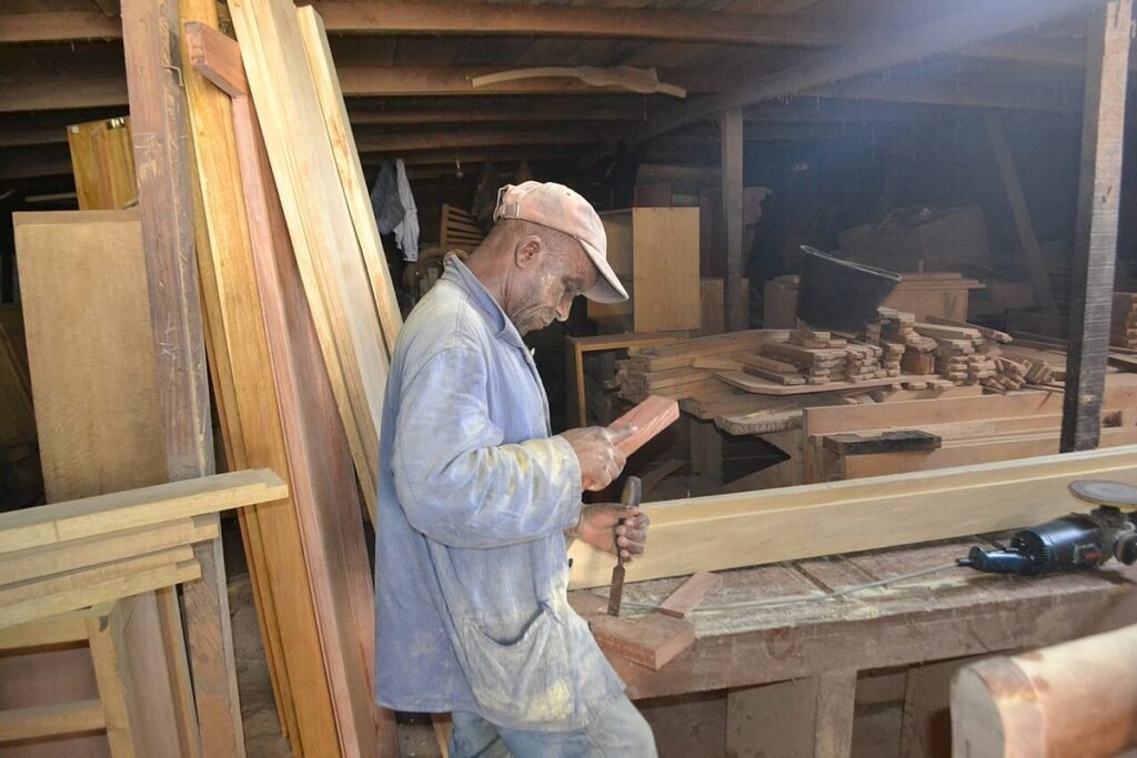 Menuisier travaillant une pièce de bois au ciseau dans son atelier